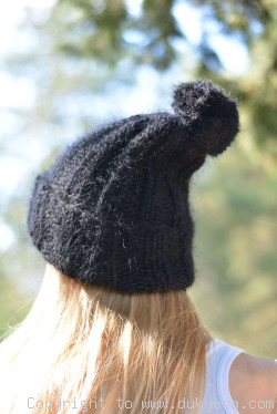 Warm winter ski hat with pompon knitted in black