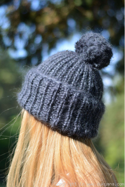 Warm winter ski hat with pompon knitted in navy blue