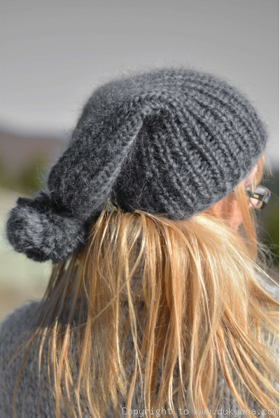 Thick winter ski hat with pompon knitted in steel gray