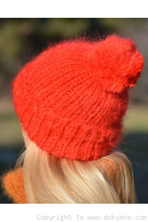 Warm winter ski hat with pompon knitted in bright red